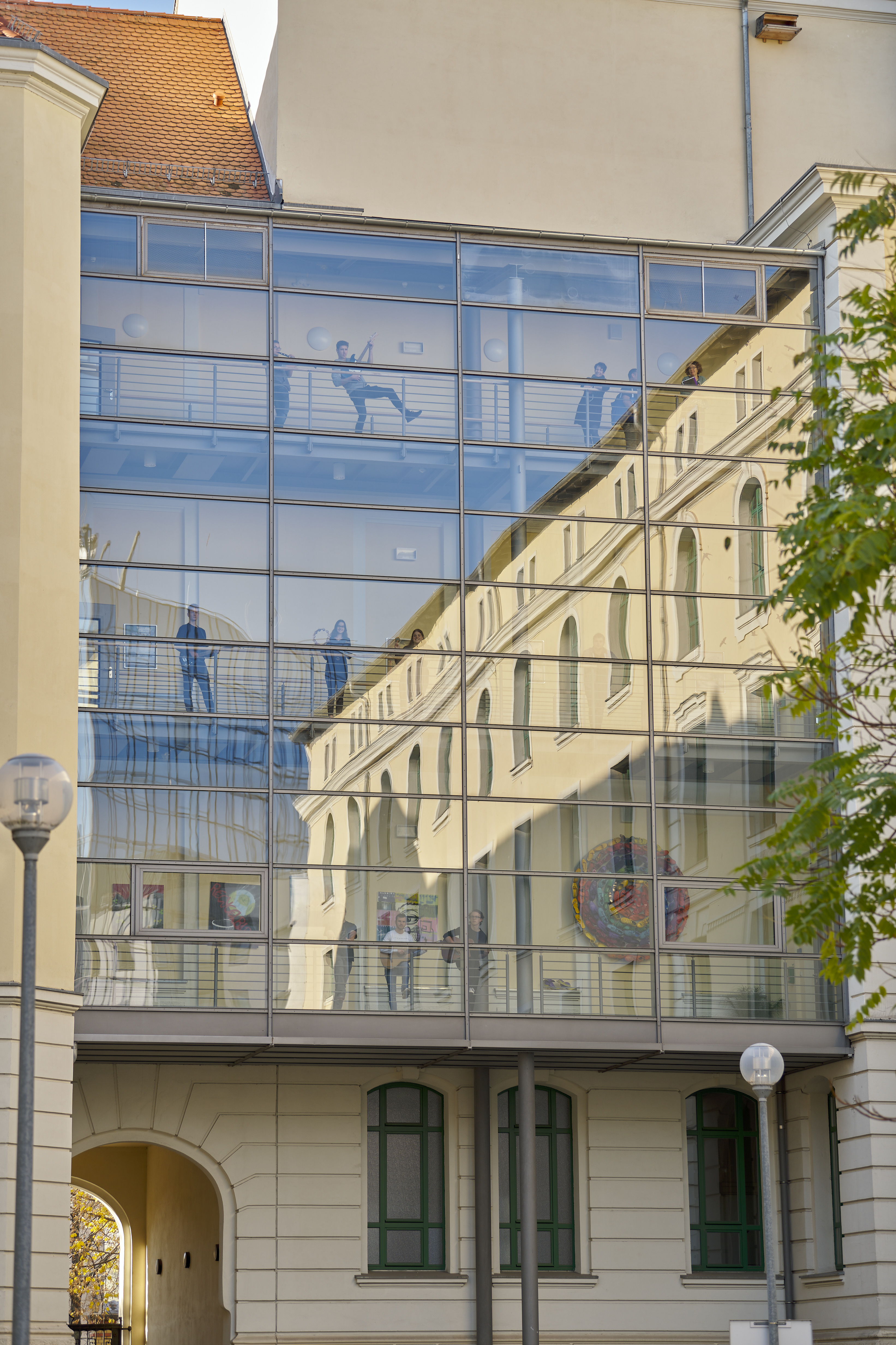 Glasbau der Schule mit Spiegelung des historischen Gebäudes
